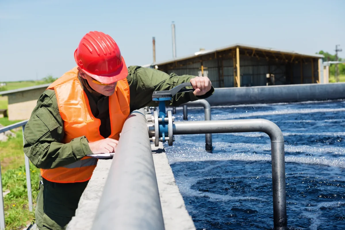 Engineer checking pipework above an aerated wastewater tank